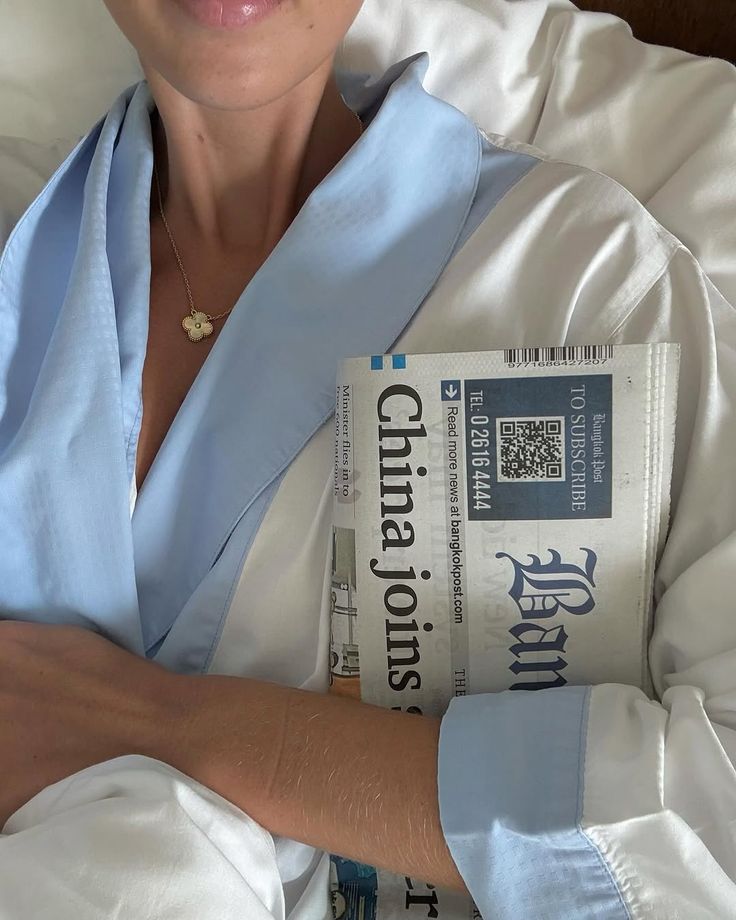 an image of a women in bed with a newspaper